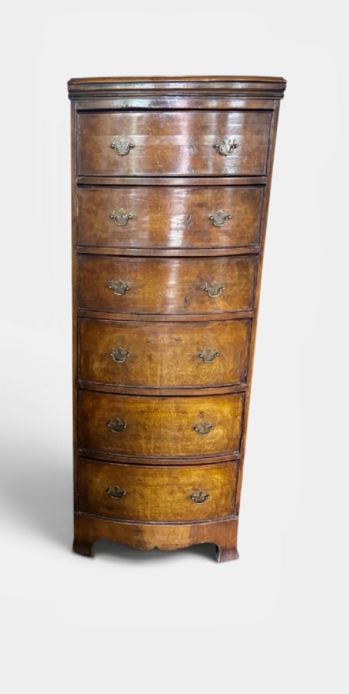 An early 20th-century figured walnut bow-front tallboy featuring six stacked drawers with brass bail handles and bracket feet. View II