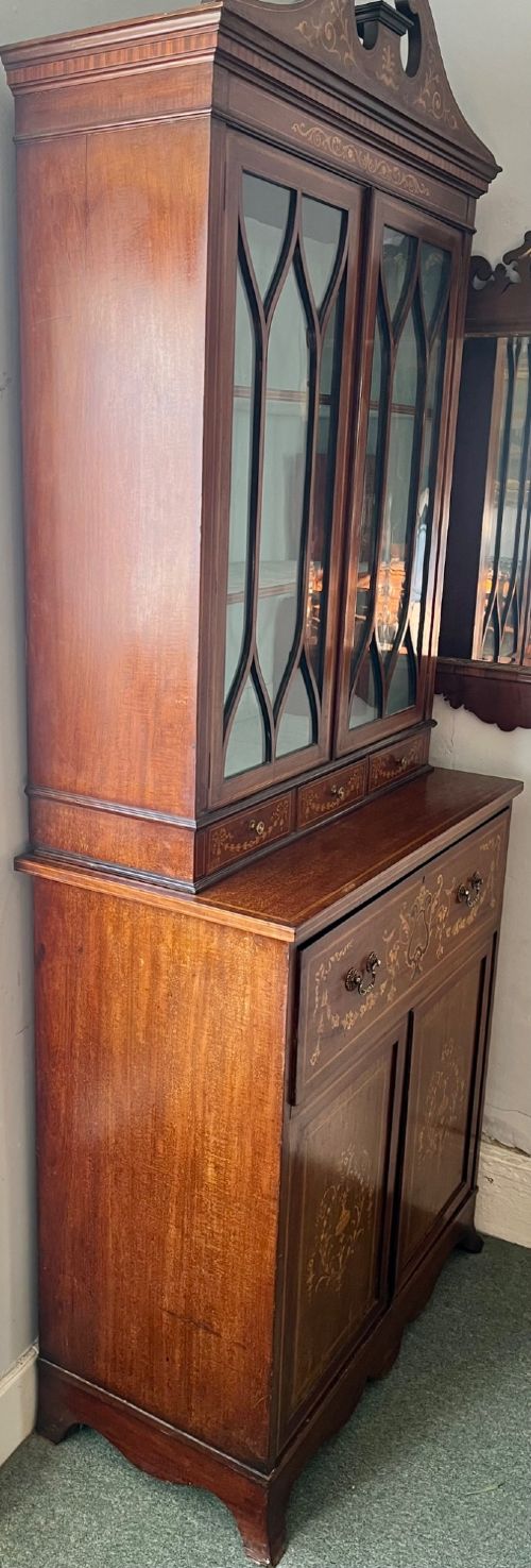 An Edwardian mahogany secretaire bookcase featuring satinwood marquetry inlays, a swan-neck pediment, glazed upper doors, and a pull-out desk drawer above lower cupboards. View VI