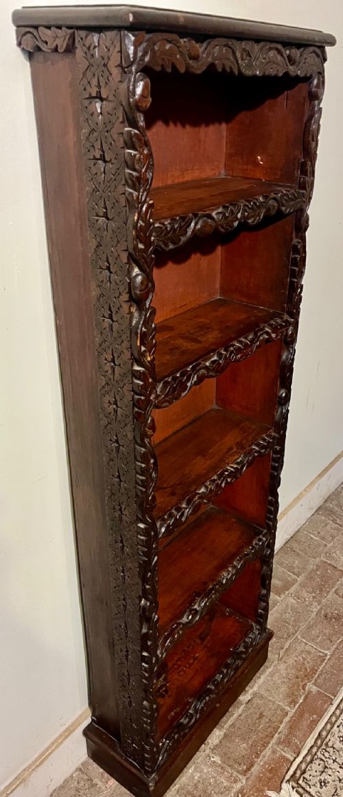 A tall, narrow Victorian open bookcase made of dark carved oak and pine with five shelves decorated with leaf borders. View VIII