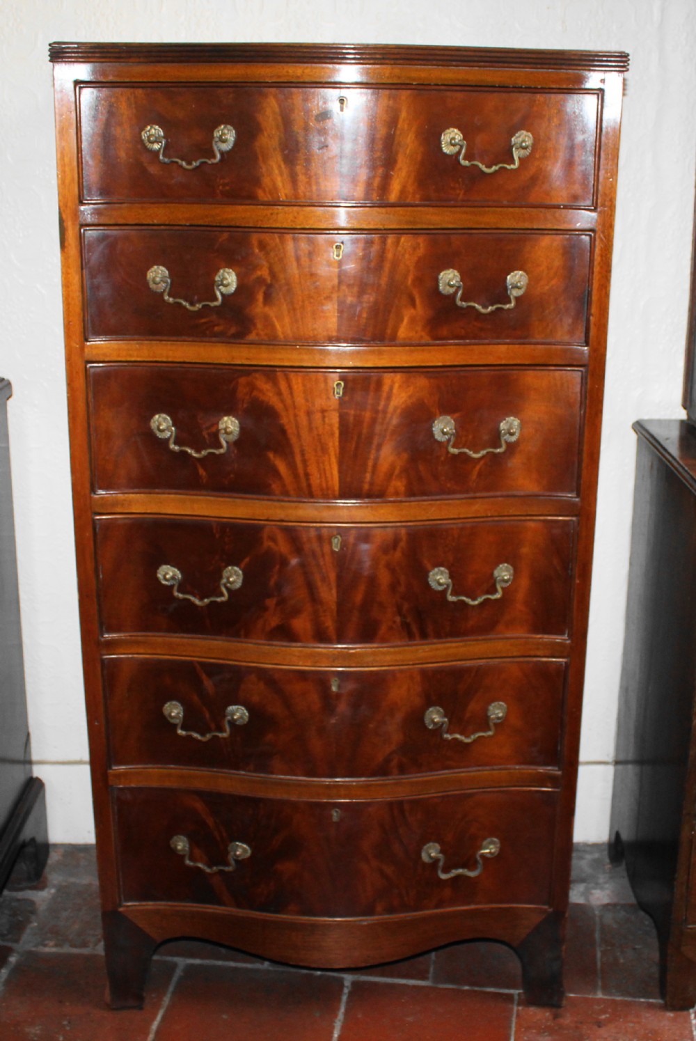Mahogany tall and narrow serpentine chest of drawers