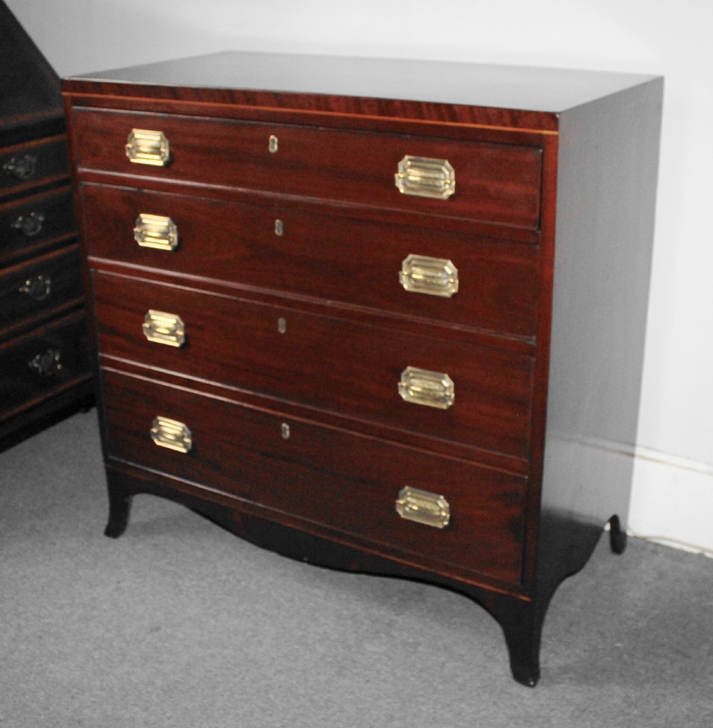 A Regency figured mahogany chest of four graduated drawers featuring brass handles and splayed bracket feet. View VI