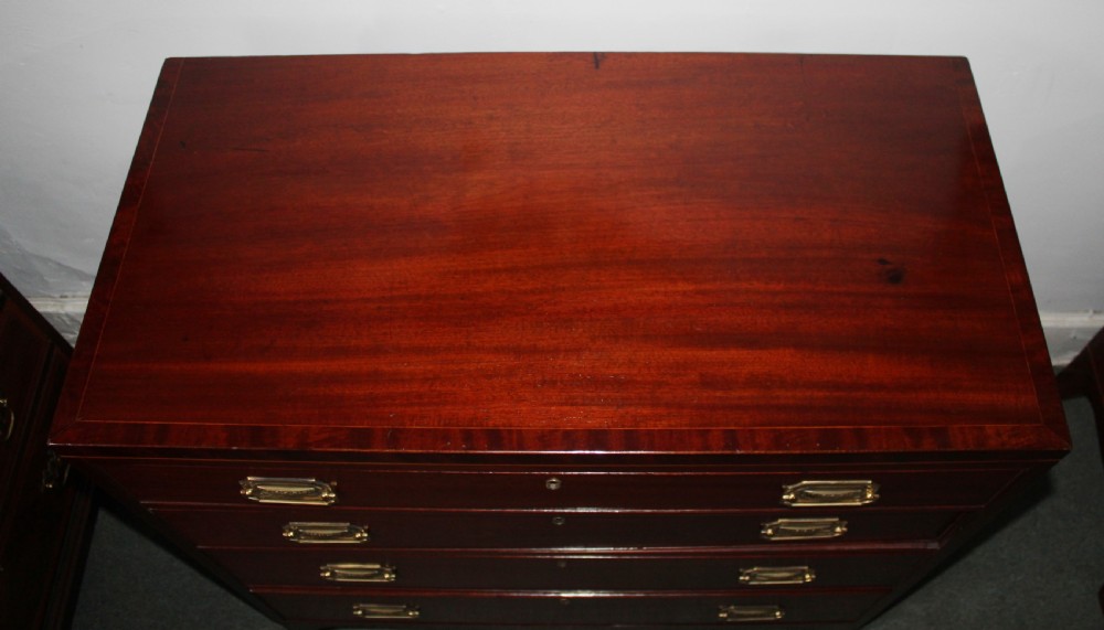 A Regency figured mahogany chest of four graduated drawers featuring brass handles and splayed bracket feet. View VIII