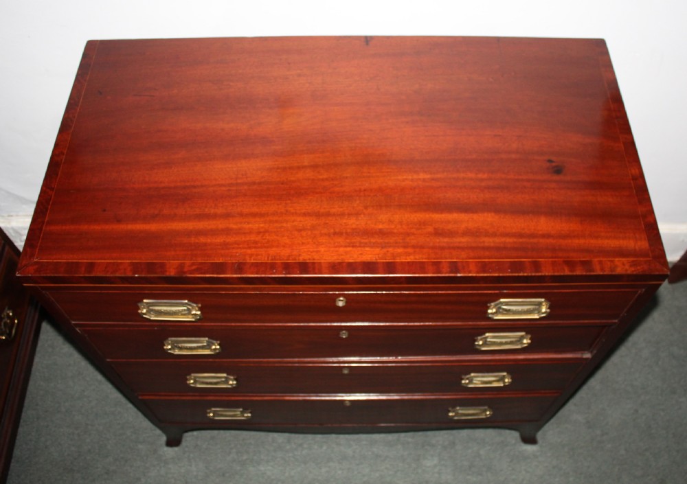A Regency figured mahogany chest of four graduated drawers featuring brass handles and splayed bracket feet. View IX