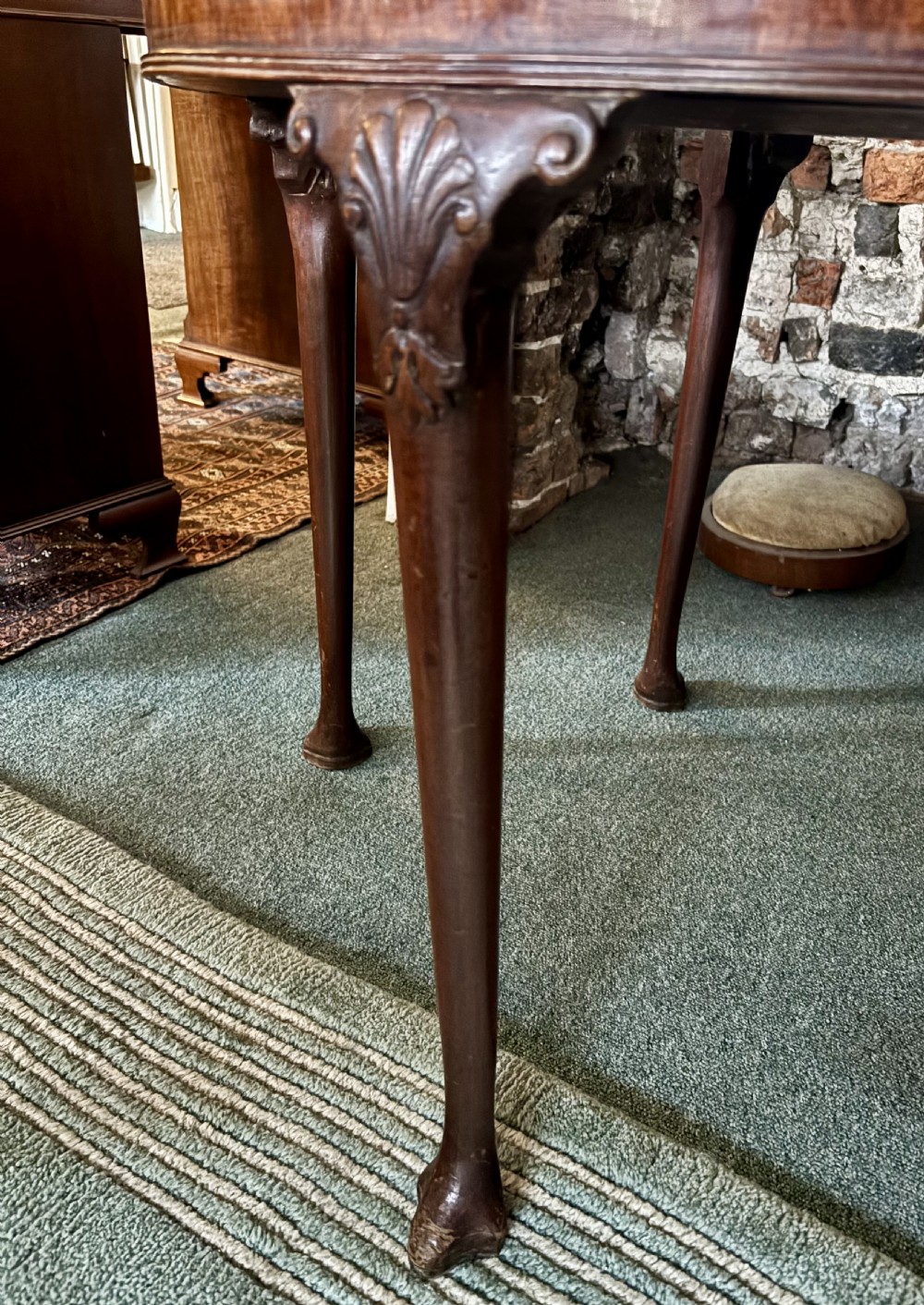 A George III mahogany demi-lune card table with carved shell knees and cabriole legs. View VI