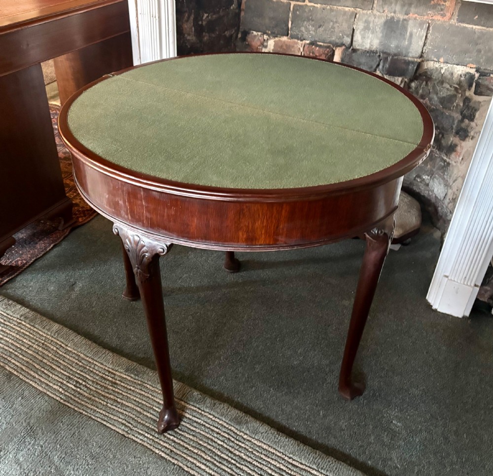 A George III mahogany demi-lune card table with carved shell knees and cabriole legs. View VII