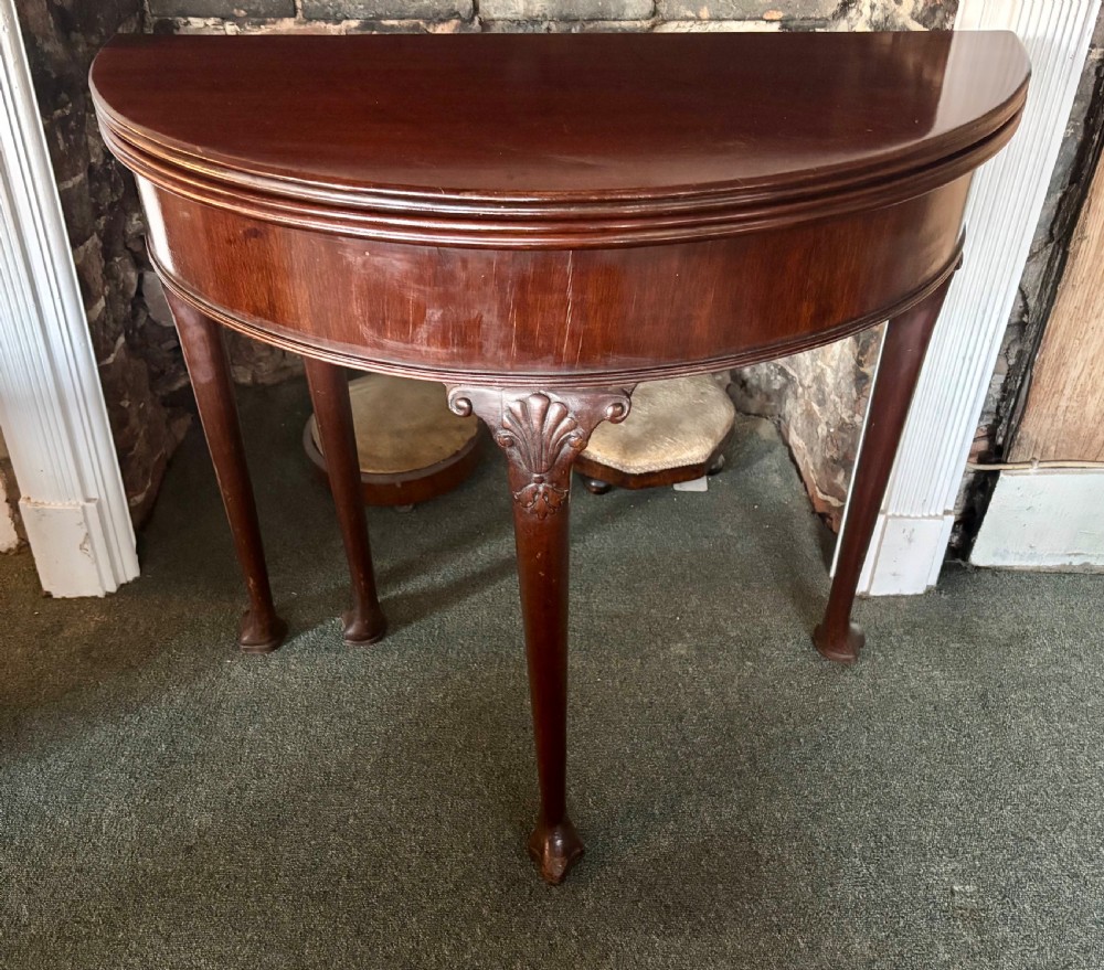 A George III mahogany demi-lune card table with carved shell knees and cabriole legs. View XII