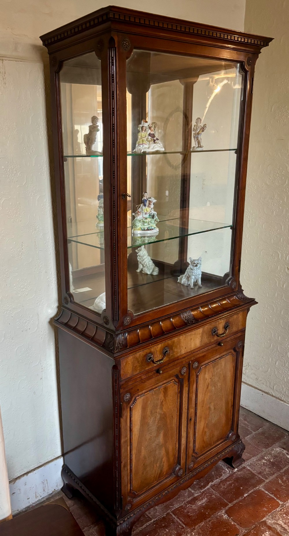 An early twentieth-century glazed mahogany display cabinet featuring an upper single glazed door section above a single drawer and double cupboard base. View VI