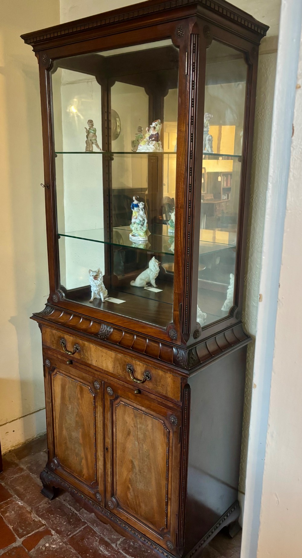 An early twentieth-century glazed mahogany display cabinet featuring an upper single glazed door section above a single drawer and double cupboard base. View VIII