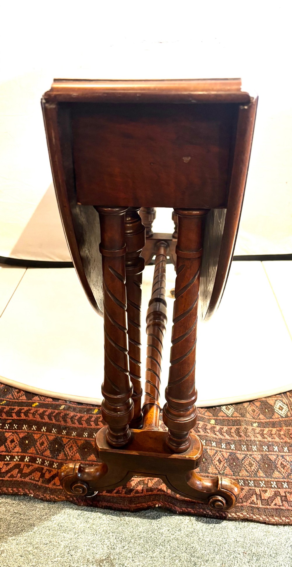 A Victorian burr walnut oval Sutherland table with detailed floral marquetry inlays, turned legs, and drop leaves extended. View V