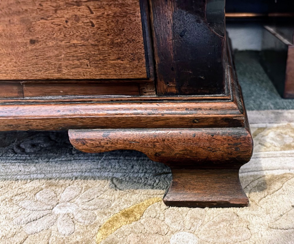 A George III walnut small chest of drawers with decorative brass handles, fluted canted corners, and bracket feet. View VIII