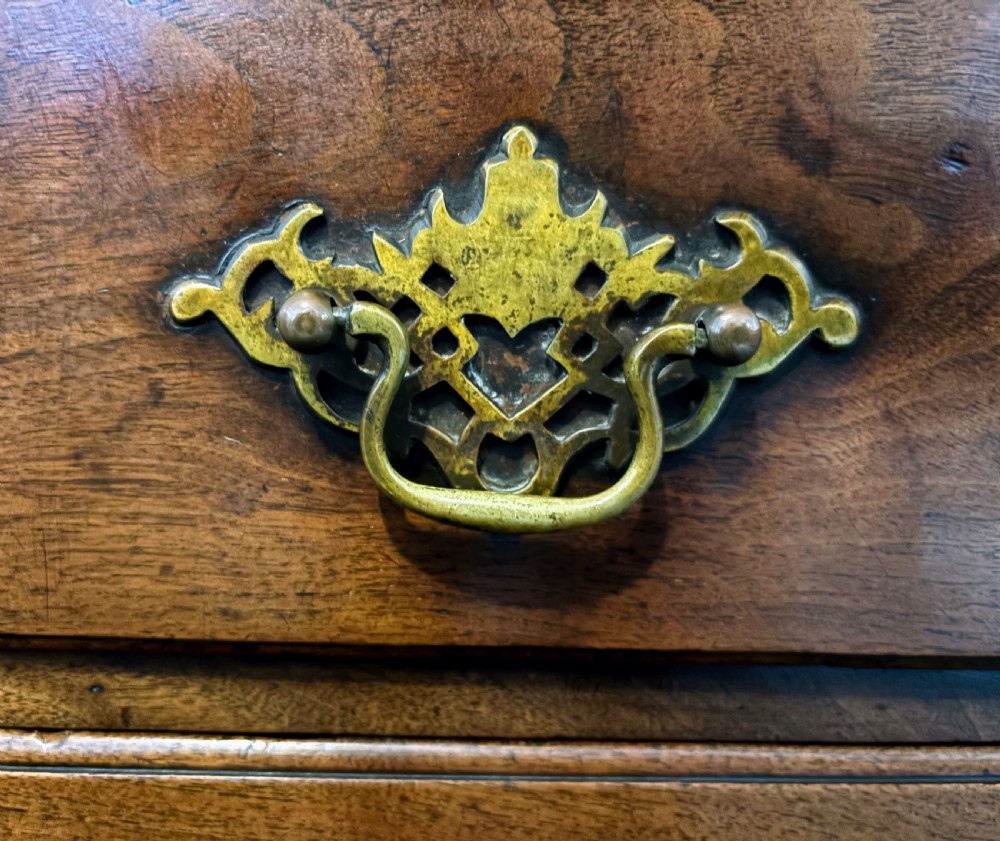 A George III walnut small chest of drawers with decorative brass handles, fluted canted corners, and bracket feet. View X