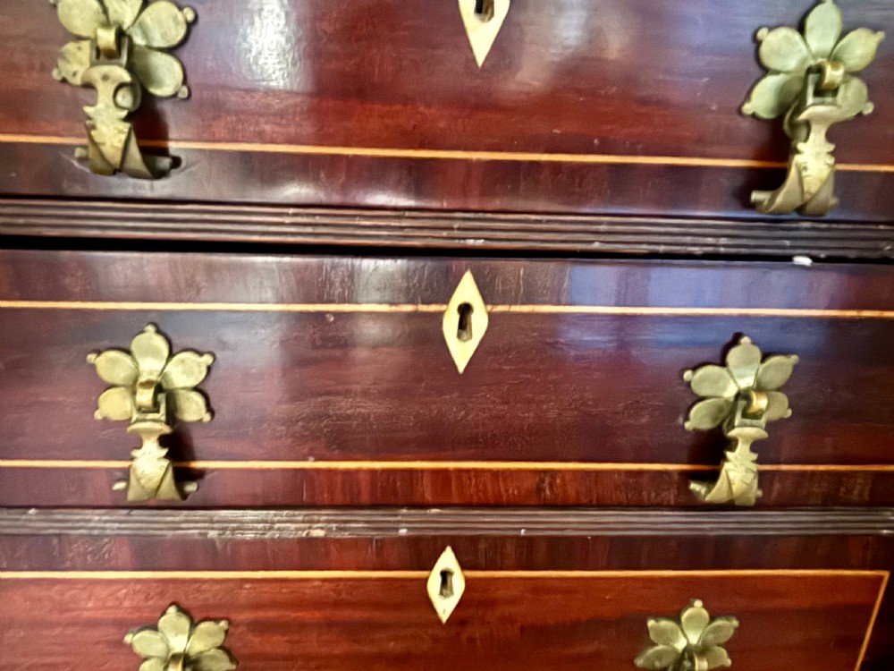 A small 19th-century mahogany cabinet featuring two open outer doors displaying four inlaid drawers with floral brass handles, supported on cabriole legs. View VI