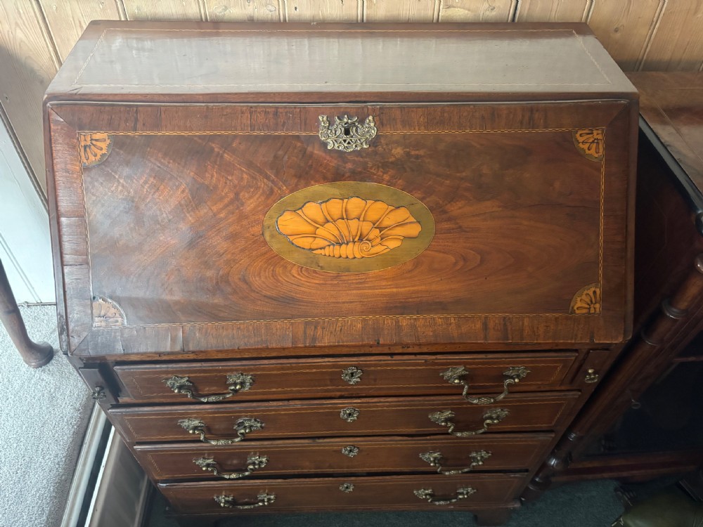 An 18th-century George III mahogany slant-front bureau featuring satinwood shell inlays and four graduating drawers with brass handles. View XII