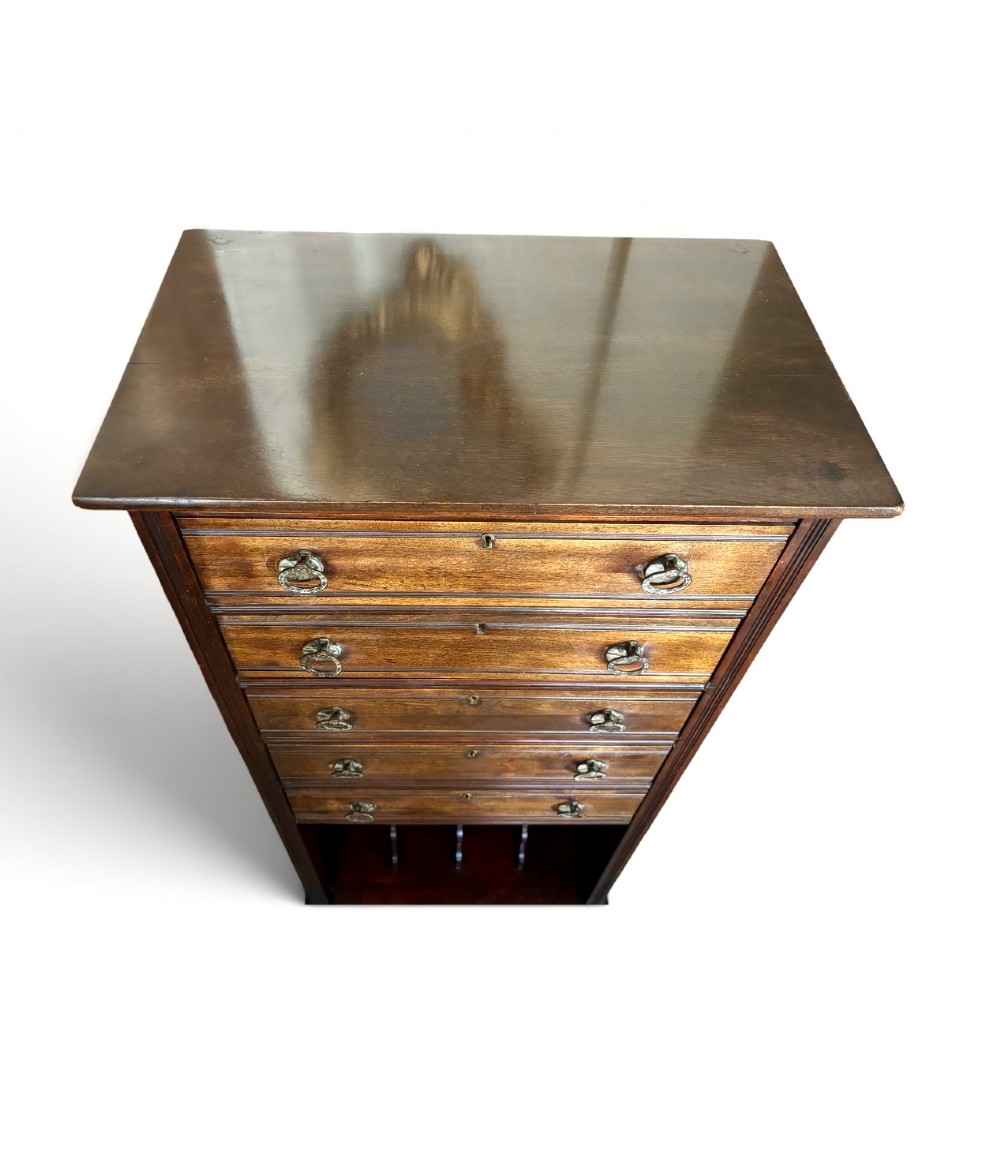 An early 20th-century tall and narrow mahogany chest featuring five drawers over an open lower section with vertical dividers. View III