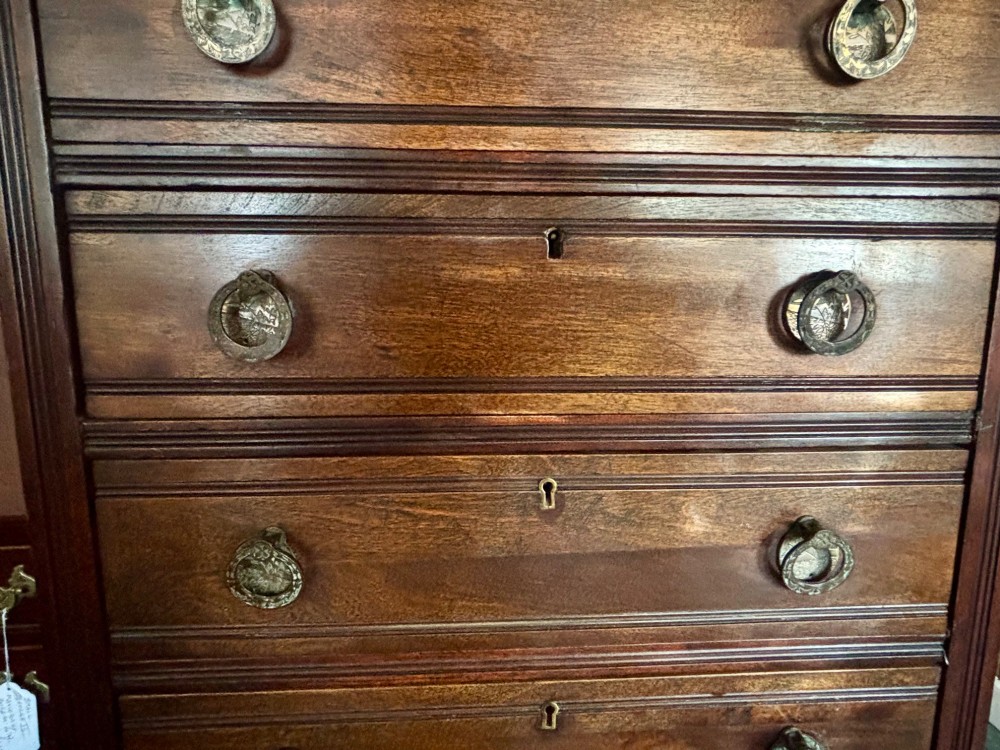 An early 20th-century tall and narrow mahogany chest featuring five drawers over an open lower section with vertical dividers. View V