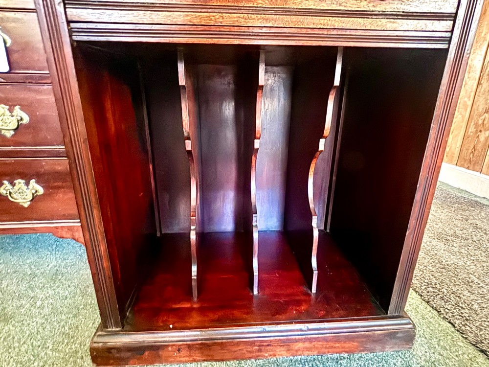 An early 20th-century tall and narrow mahogany chest featuring five drawers over an open lower section with vertical dividers. View VI