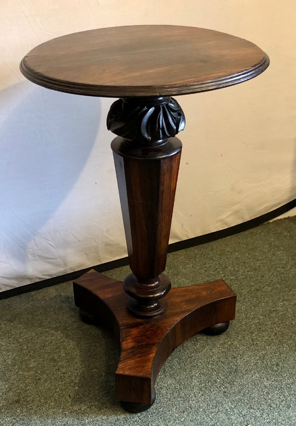A Victorian rosewood wine table with a round top resting on a central column and a triform base. View IV