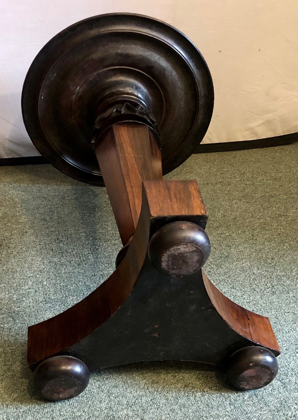 A Victorian rosewood wine table with a round top resting on a central column and a triform base. View V