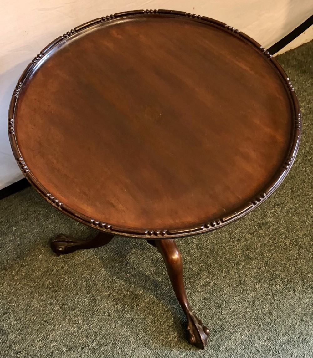 A small early twentieth-century mahogany tripod wine table featuring a circular top with a beaded rim, turned stem, and three cabriole legs. View II