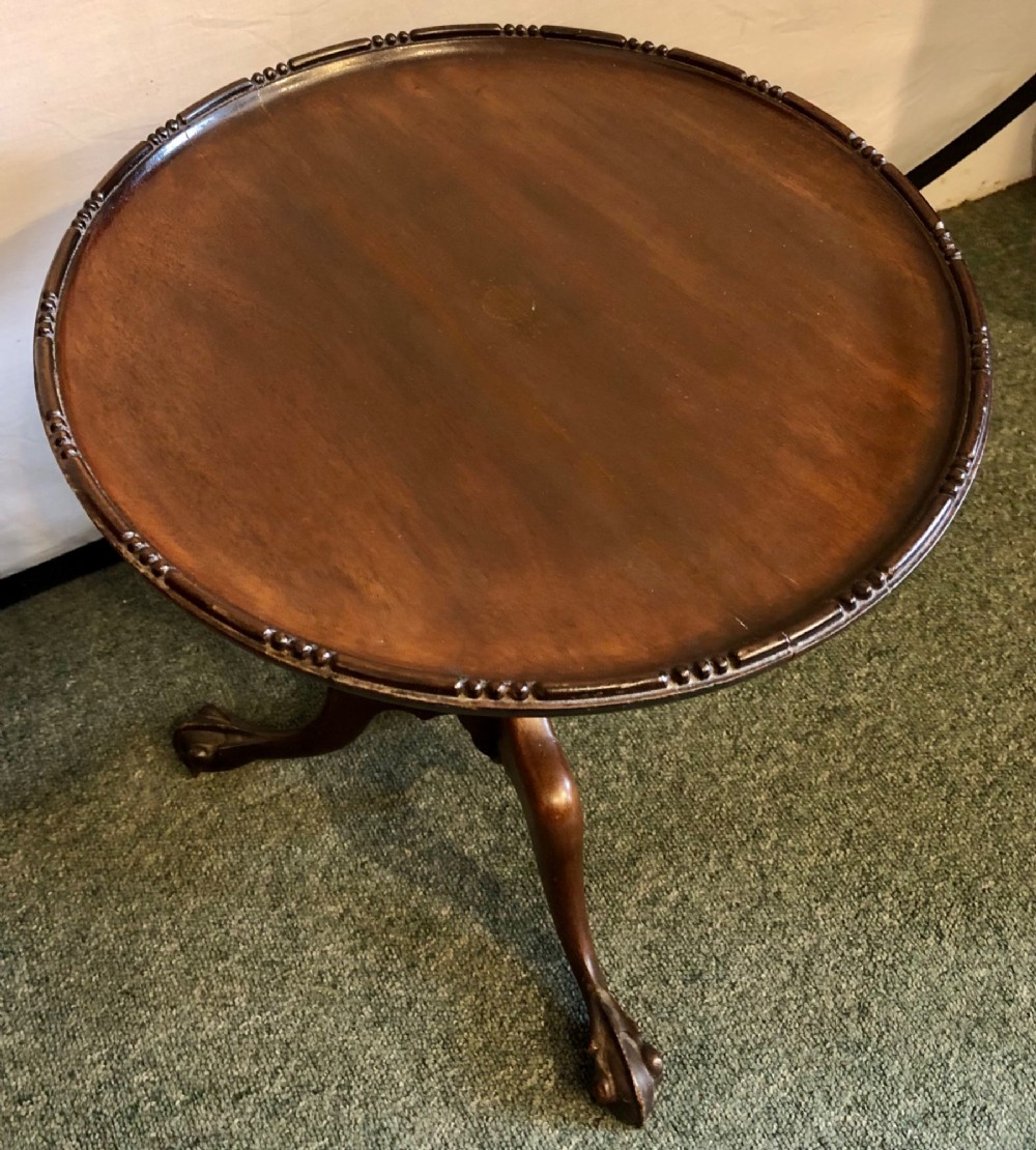 A small early twentieth-century mahogany tripod wine table featuring a circular top with a beaded rim, turned stem, and three cabriole legs. View IV