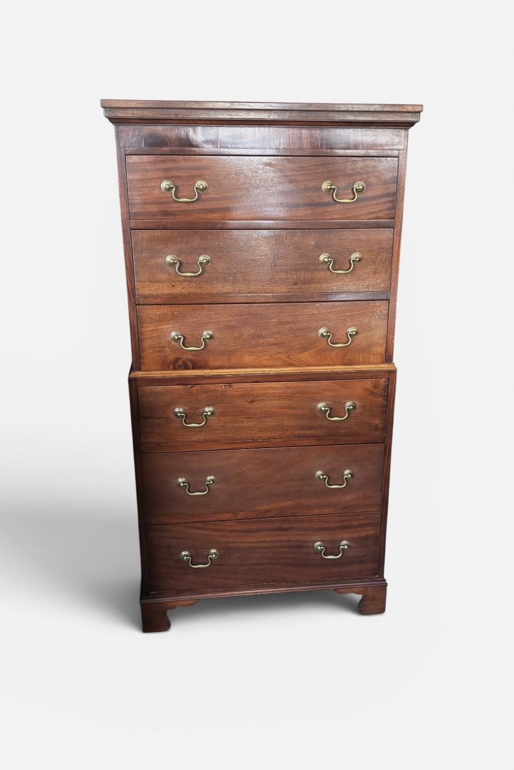 An early 20th century mahogany tallboy chest featuring six graduated drawers with brass drop handles and bracket feet. View II