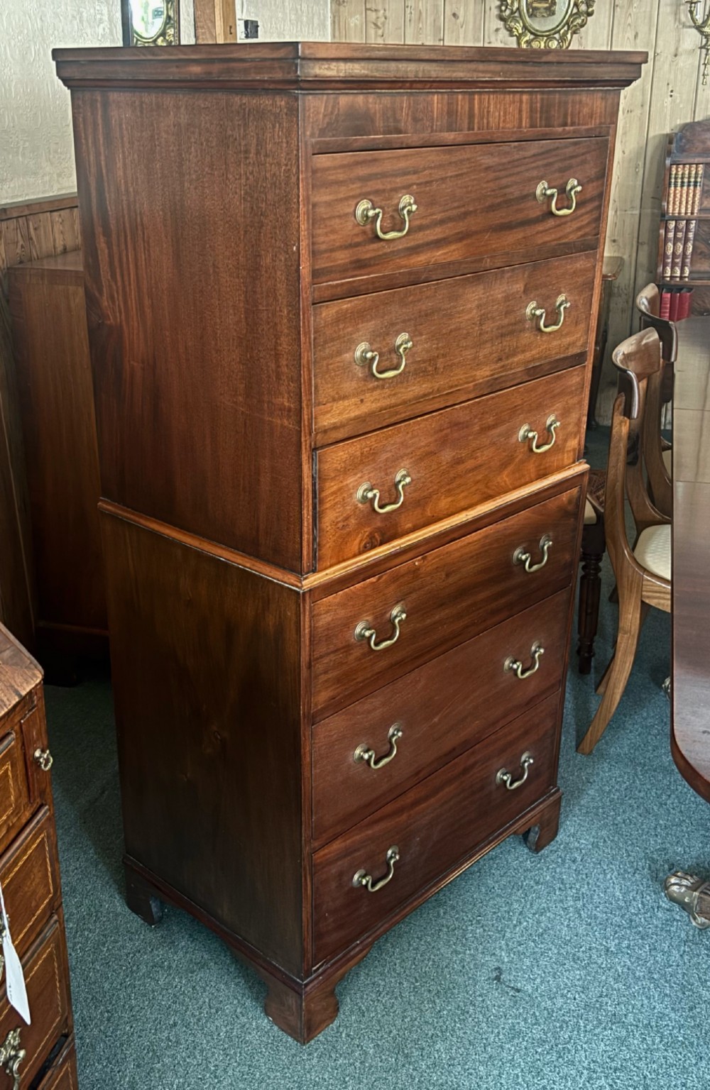 An early 20th century mahogany tallboy chest featuring six graduated drawers with brass drop handles and bracket feet. View VI
