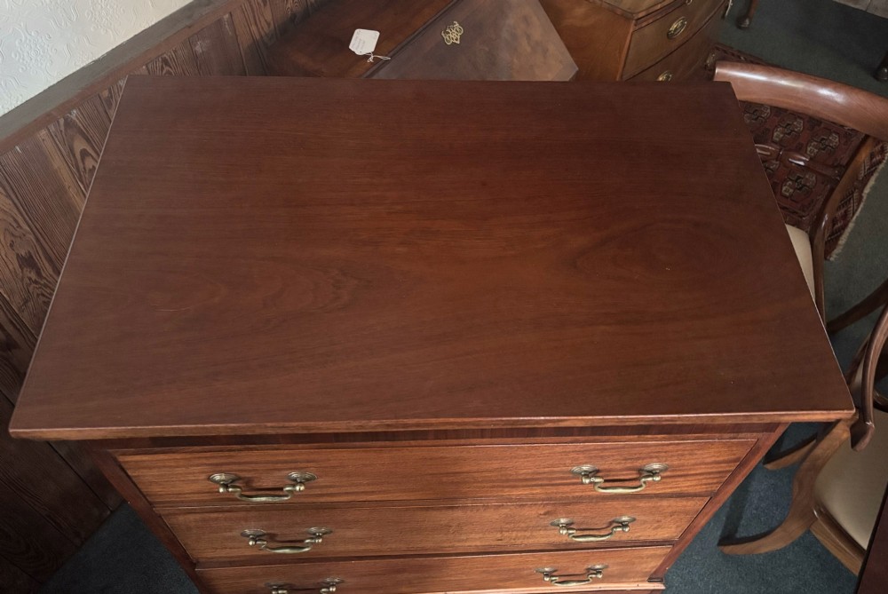 An early 20th century mahogany tallboy chest featuring six graduated drawers with brass drop handles and bracket feet. View VII