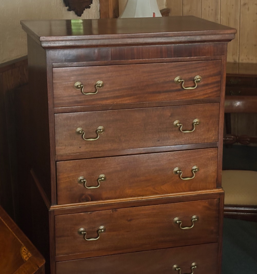 An early 20th century mahogany tallboy chest featuring six graduated drawers with brass drop handles and bracket feet. View IX