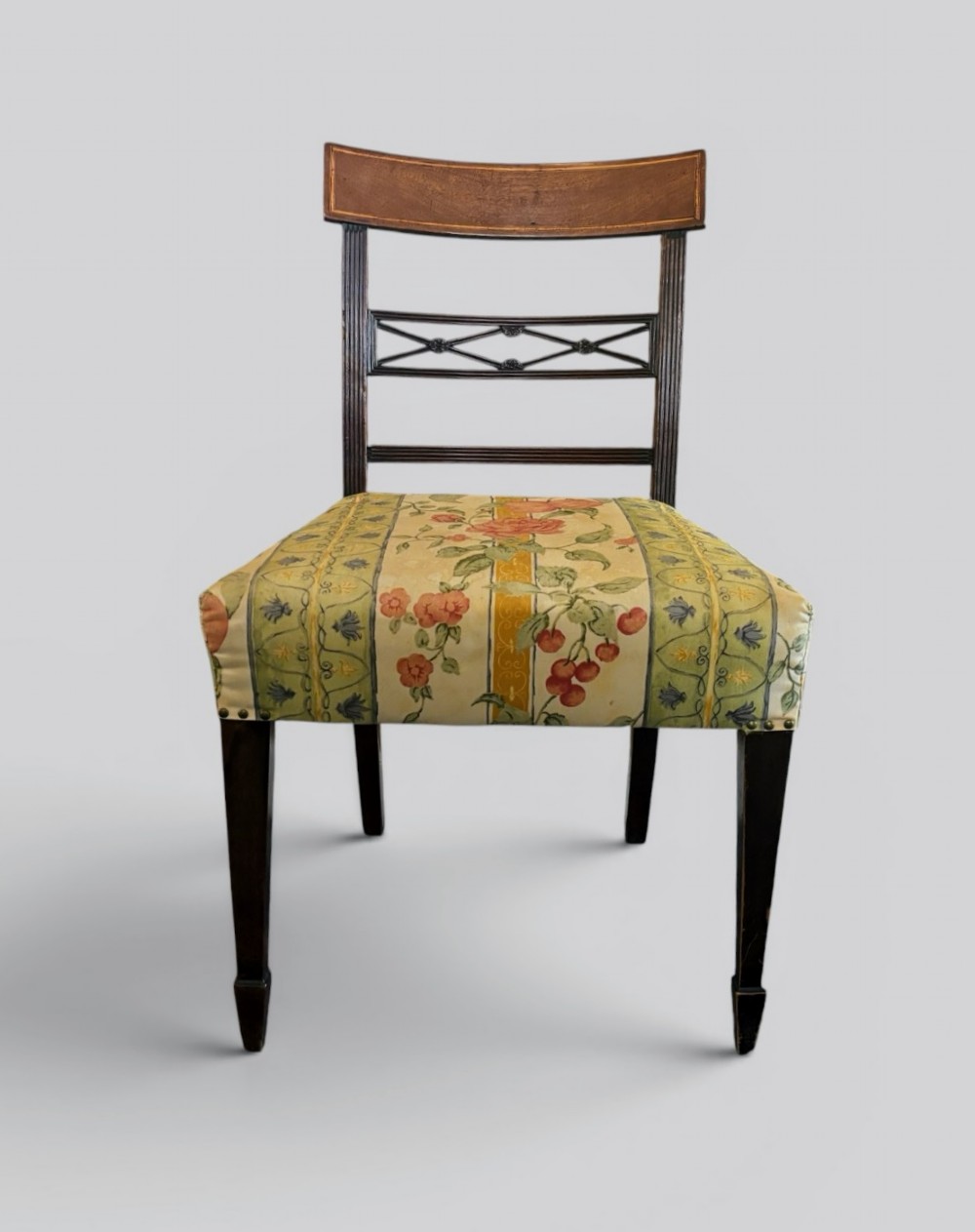 A set of six early nineteenth century mahogany dining chairs featuring tablet top rails, reeded frames, lattice splats, and floral striped fabric seats. View III