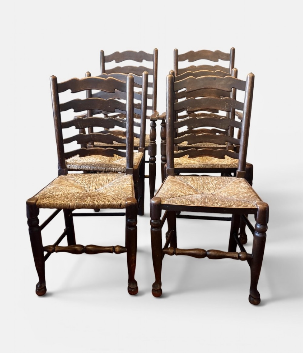 A set of dark oak ladder back chairs featuring woven rush seats and turned front legs. View II