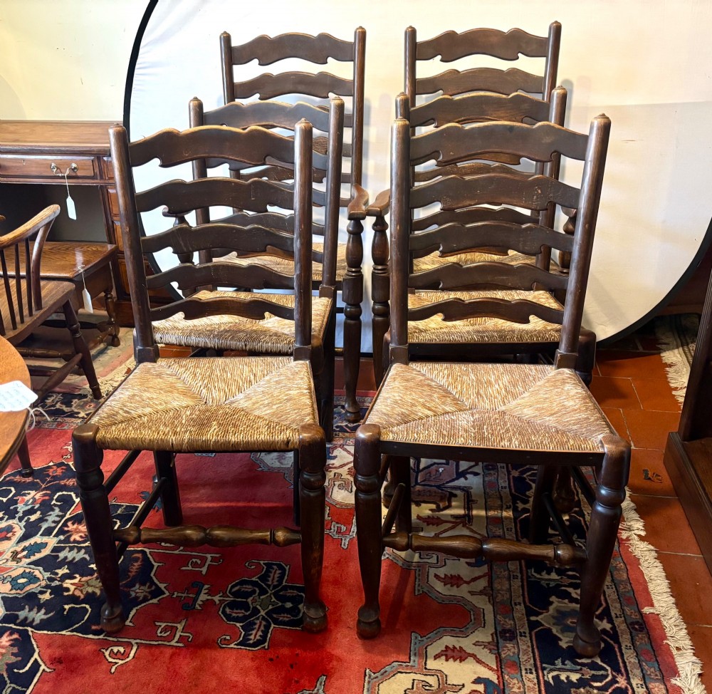 A set of dark oak ladder back chairs featuring woven rush seats and turned front legs. View VIII