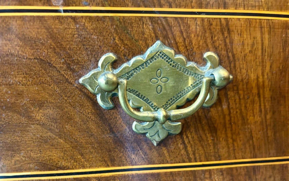 An antique George III walnut slant-front bureau desk featuring brass drop handles, feather-banded inlay, and a graduated drawer base on bracket feet. View IV