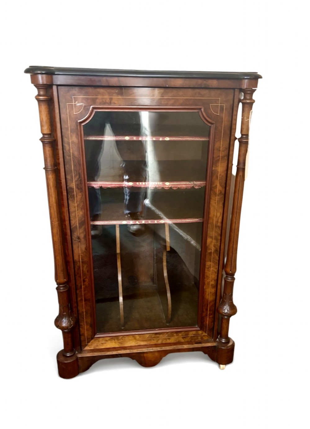 A nineteenth-century Victorian burr walnut music cabinet featuring a single glazed door, turned side pilasters, and internal shelving with embossed leather trim.