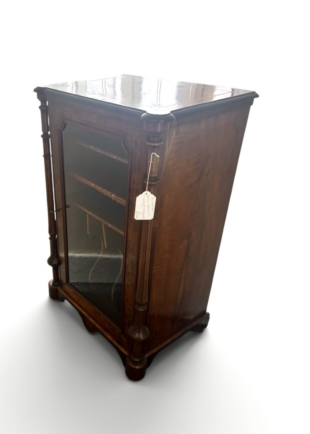 A nineteenth-century Victorian burr walnut music cabinet featuring a single glazed door, turned side pilasters, and internal shelving with embossed leather trim. View III