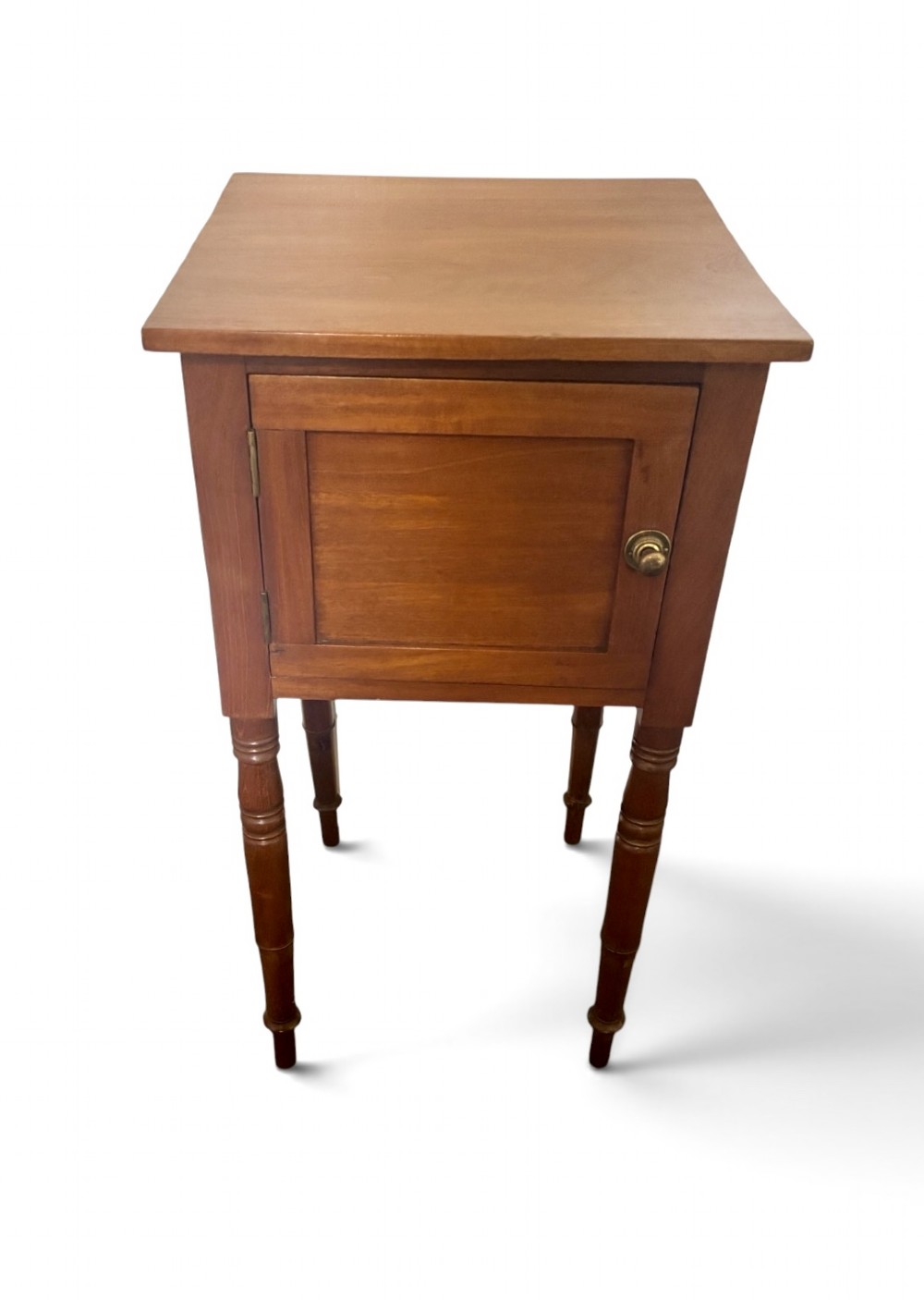 A 19th-century mahogany bedside cupboard featuring a single panelled cupboard door with a brass knob and tall turned legs. View II