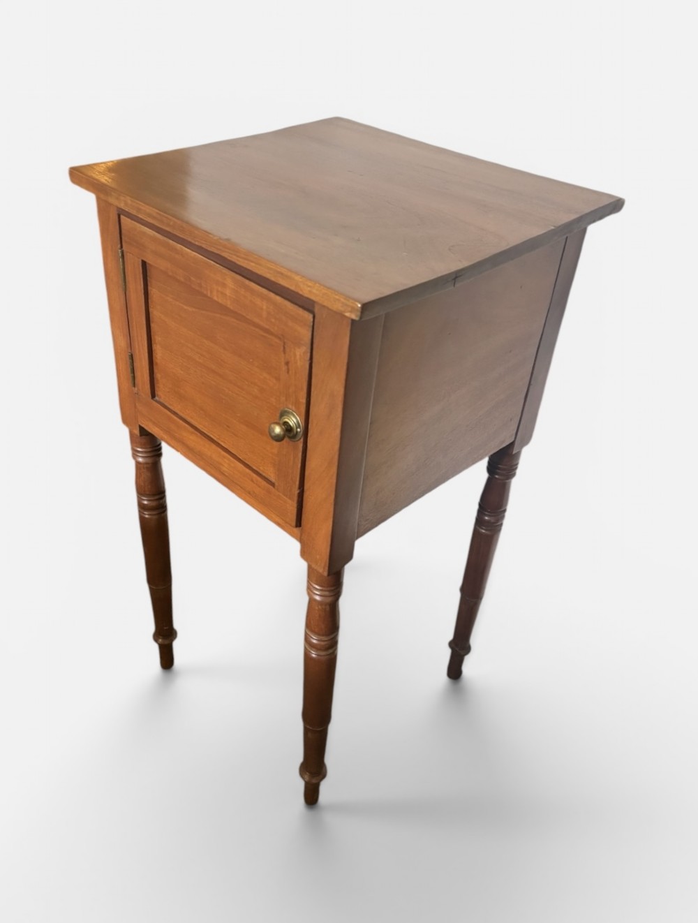 A 19th-century mahogany bedside cupboard featuring a single panelled cupboard door with a brass knob and tall turned legs. View III