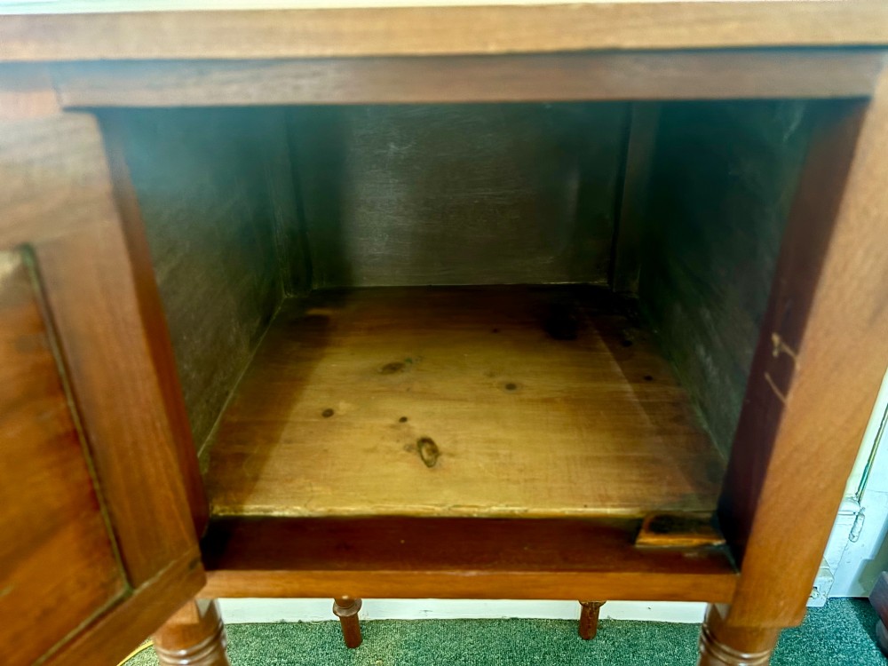 A 19th-century mahogany bedside cupboard featuring a single panelled cupboard door with a brass knob and tall turned legs. View VI