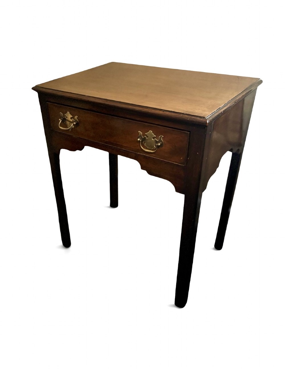 A George III dark mahogany lowboy side table with a rectangular top, a single wide drawer fitted with brass handles, a shaped apron, and four straight legs.