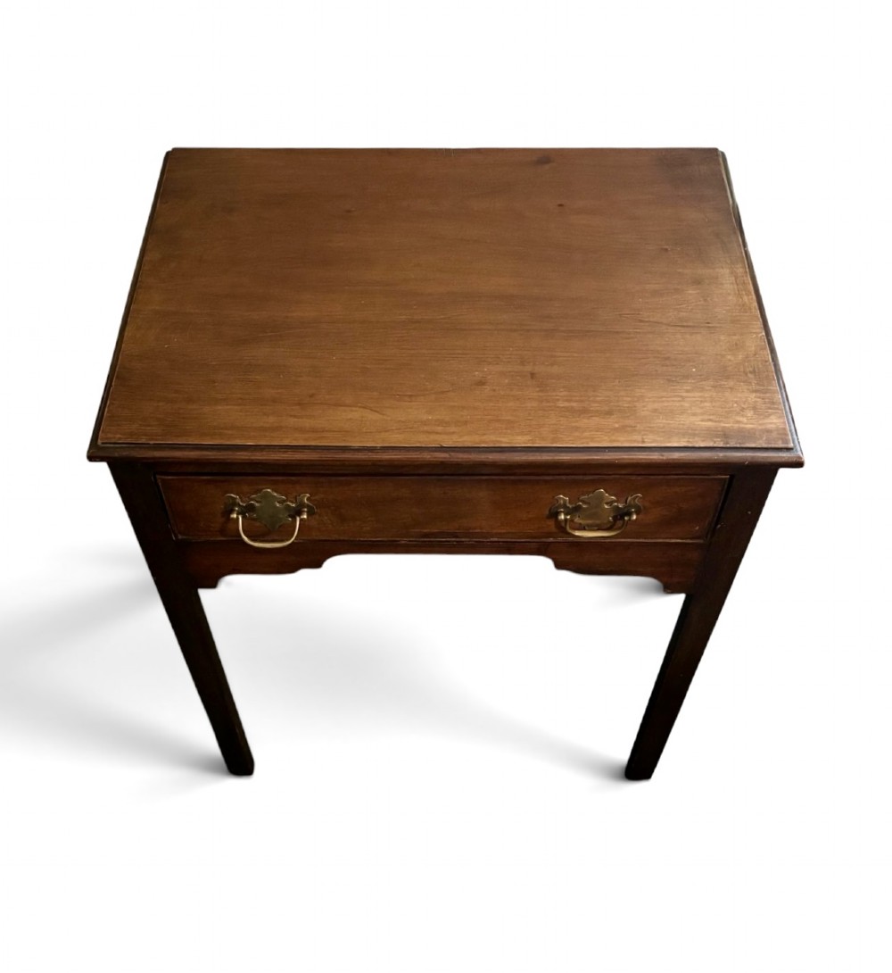 A George III dark mahogany lowboy side table with a rectangular top, a single wide drawer fitted with brass handles, a shaped apron, and four straight legs. View III
