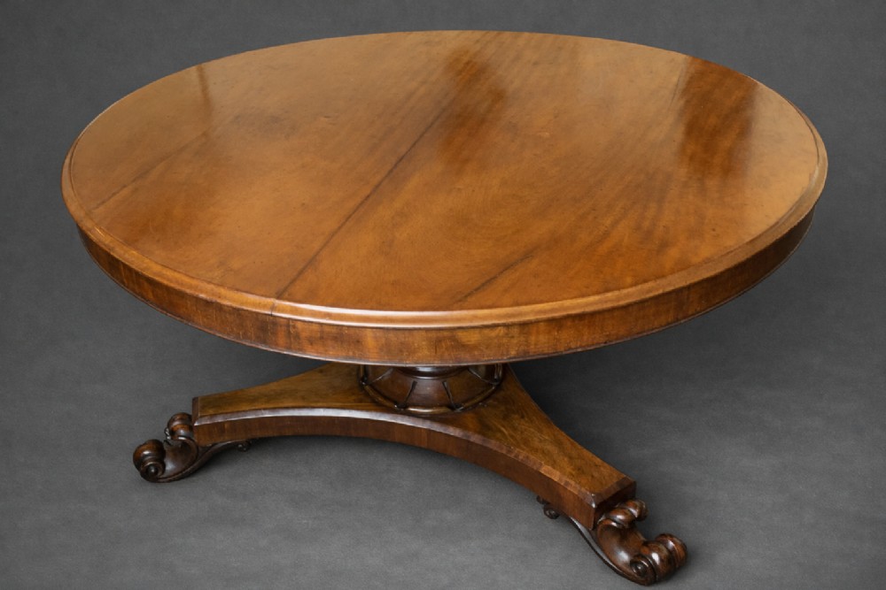 Large Regency figured mahogany tilt top round dining table