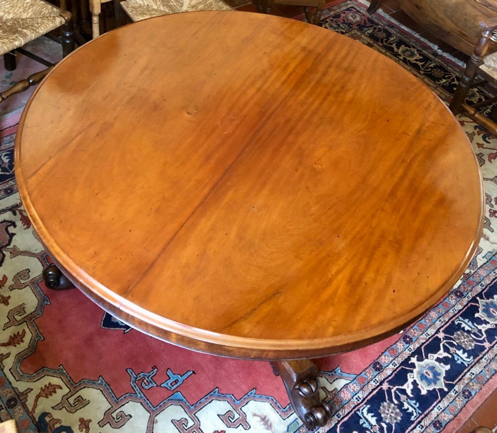 Large Regency figured mahogany tilt top round dining table View IV