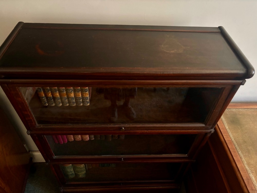 A three-tier Victorian dark oak barrister bookcase featuring glazed lifting doors with small brass knobs. View III