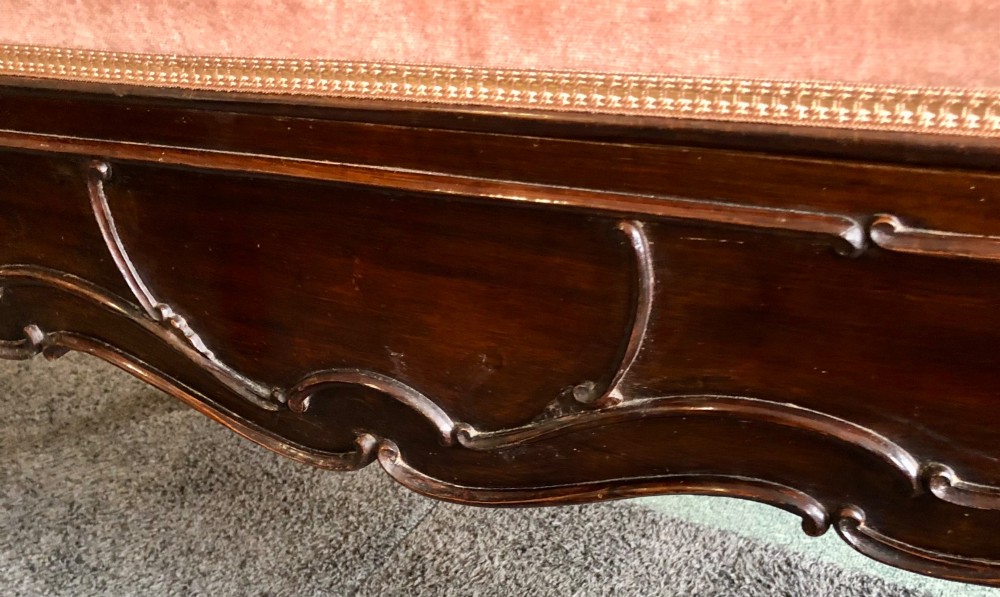 An Edwardian carved rosewood duet stool with a long, dusty-pink velvet upholstered top supported by cabriole legs. View VII