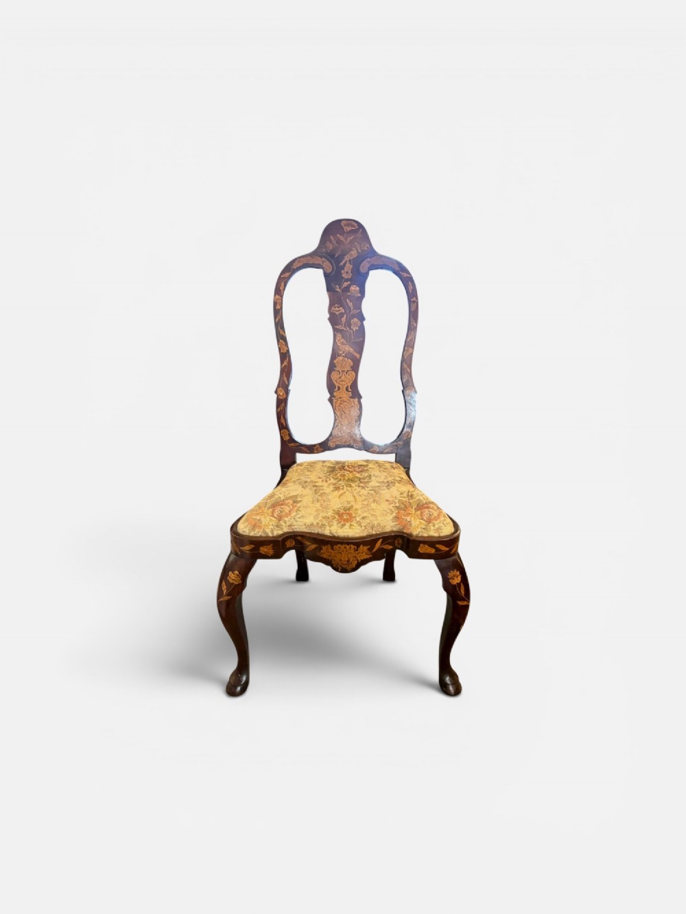An antique Dutch walnut side chair featuring detailed floral marquetry inlay across the vase splat, apron, and cabriole legs, fitted with a floral fabric drop-in seat.