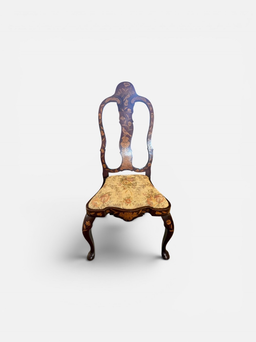 An antique Dutch walnut side chair featuring detailed floral marquetry inlay across the vase splat, apron, and cabriole legs, fitted with a floral fabric drop-in seat. View II
