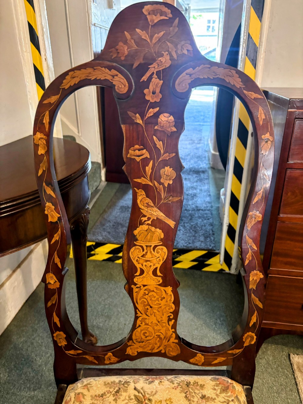 An antique Dutch walnut side chair featuring detailed floral marquetry inlay across the vase splat, apron, and cabriole legs, fitted with a floral fabric drop-in seat. View V