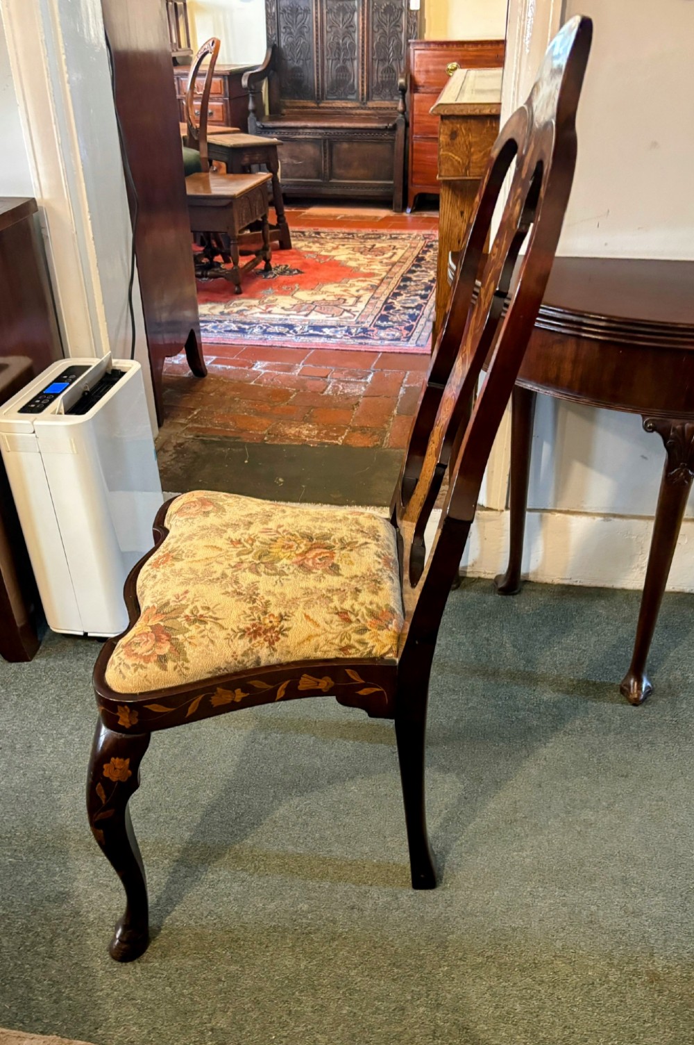 An antique Dutch walnut side chair featuring detailed floral marquetry inlay across the vase splat, apron, and cabriole legs, fitted with a floral fabric drop-in seat. View VI