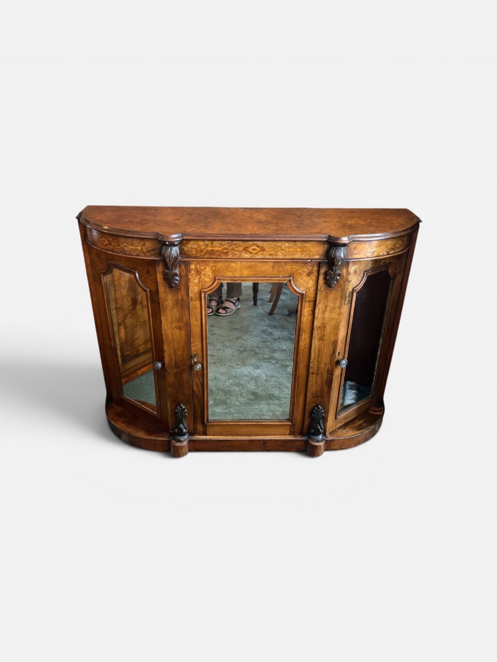 A Victorian walnut side cabinet featuring floral marquetry inlays, three glazed doors, carved corbels, and a shaped serpentine front.