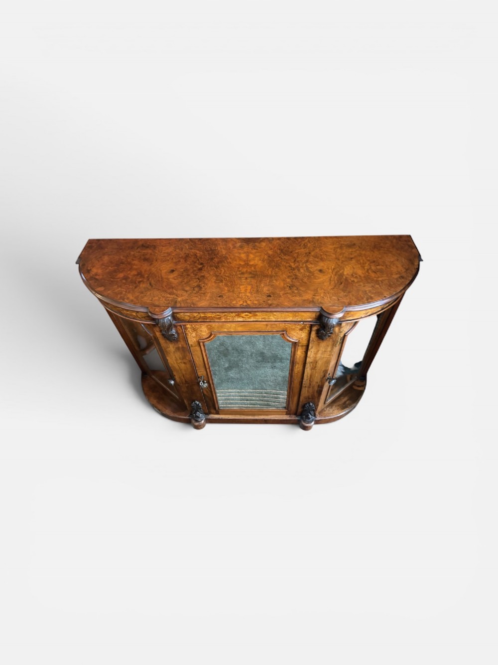 A Victorian walnut side cabinet featuring floral marquetry inlays, three glazed doors, carved corbels, and a shaped serpentine front. View II