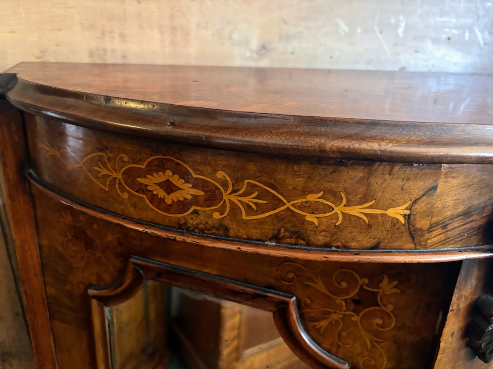 A Victorian walnut side cabinet featuring floral marquetry inlays, three glazed doors, carved corbels, and a shaped serpentine front. View VII